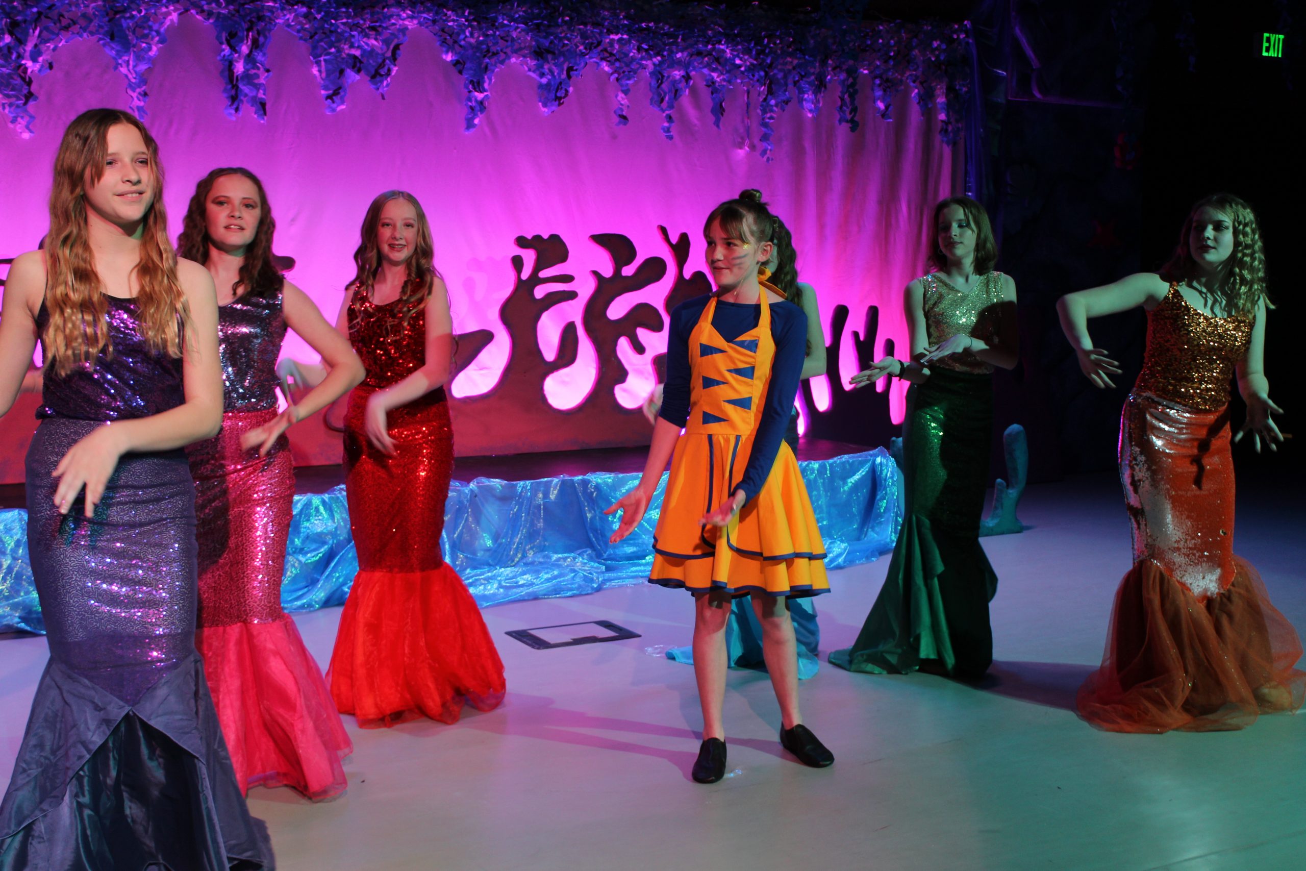 girl cast members dressed as mermaids dancing