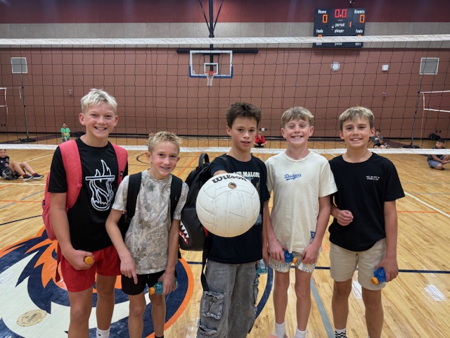 4 boys holding a volleyball
